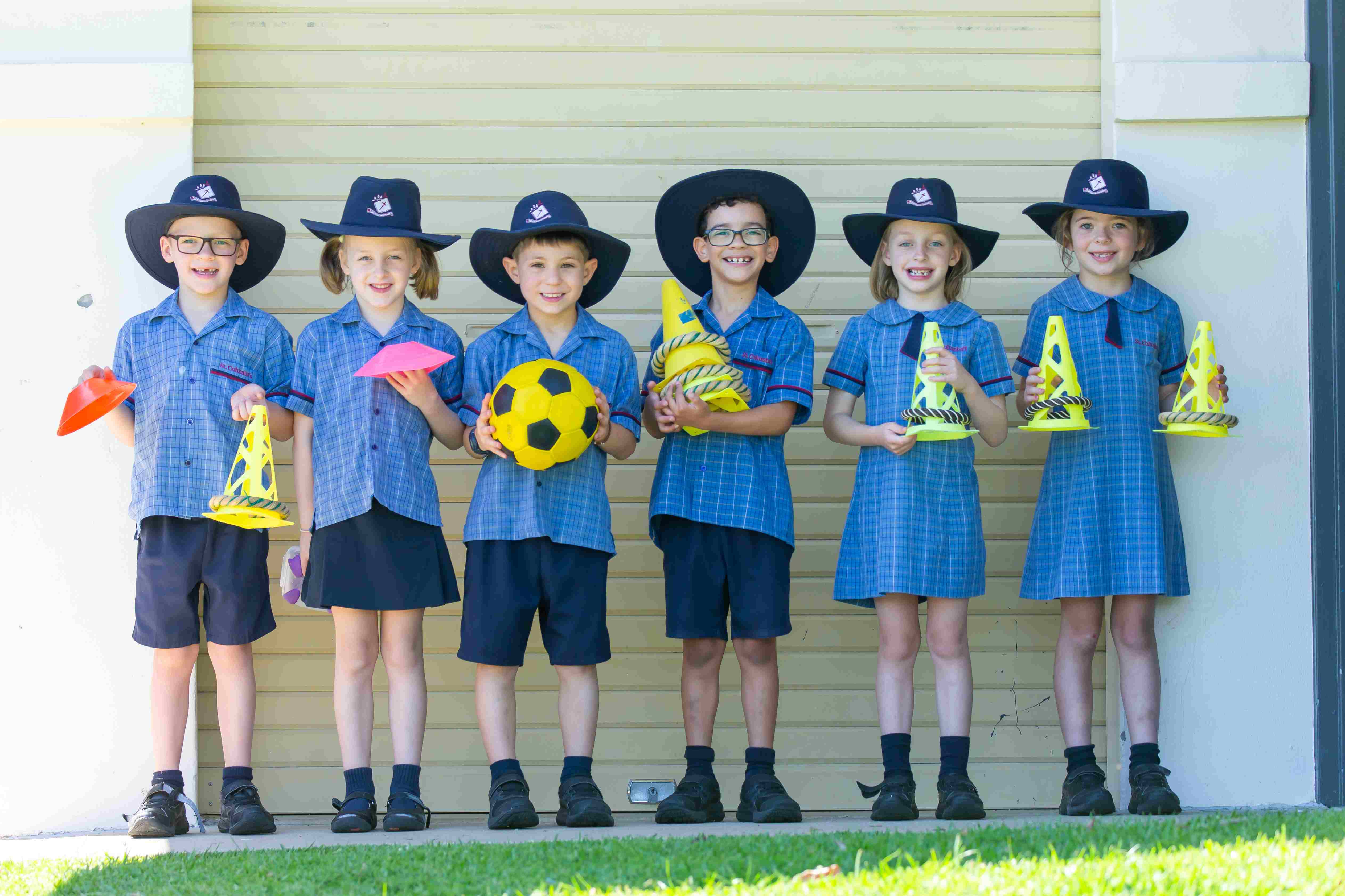 Children standing with sports equipment